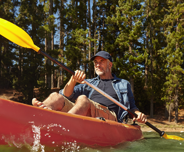 Man kayaking in the forest.