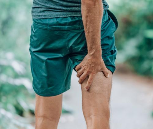 Man holding back of leg in pain